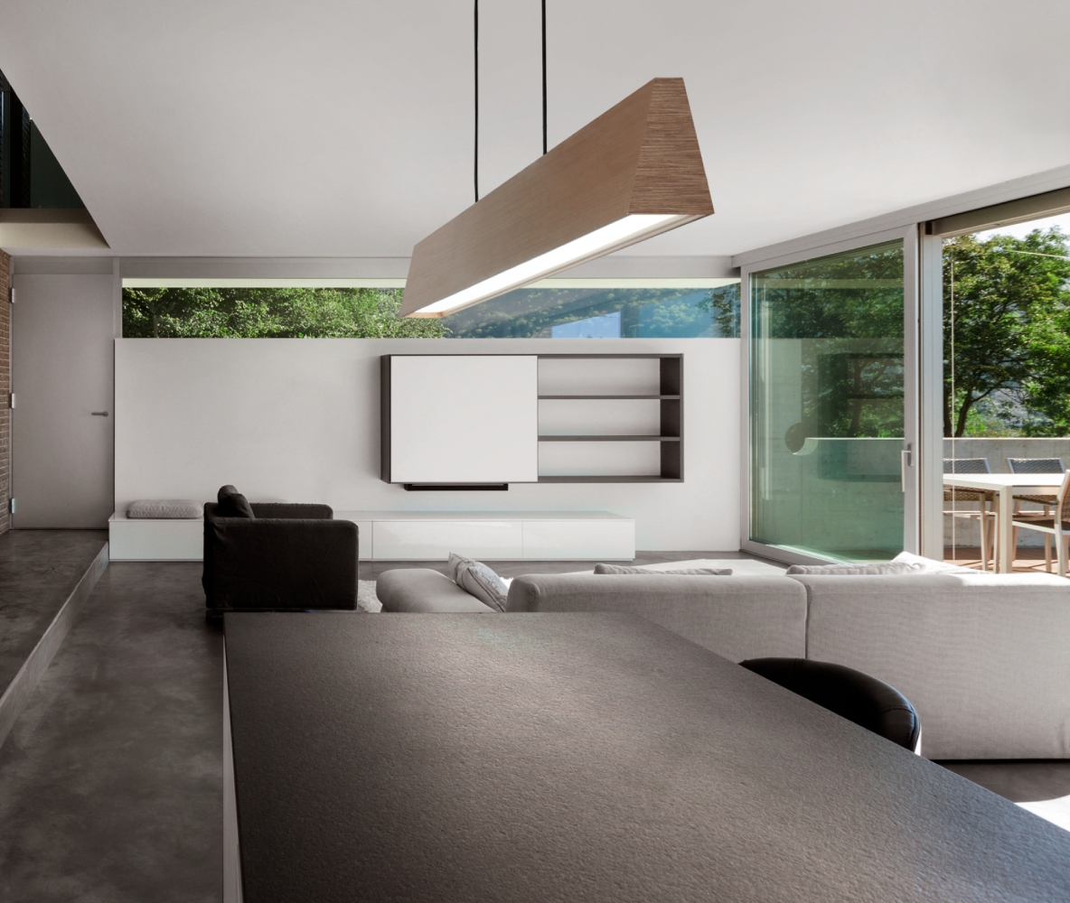 Light-Point Copenhagen EDGE Linear S2000 pendant in rose gold, providing clean, linear illumination above a contemporary dining and living space with minimalist architecture.