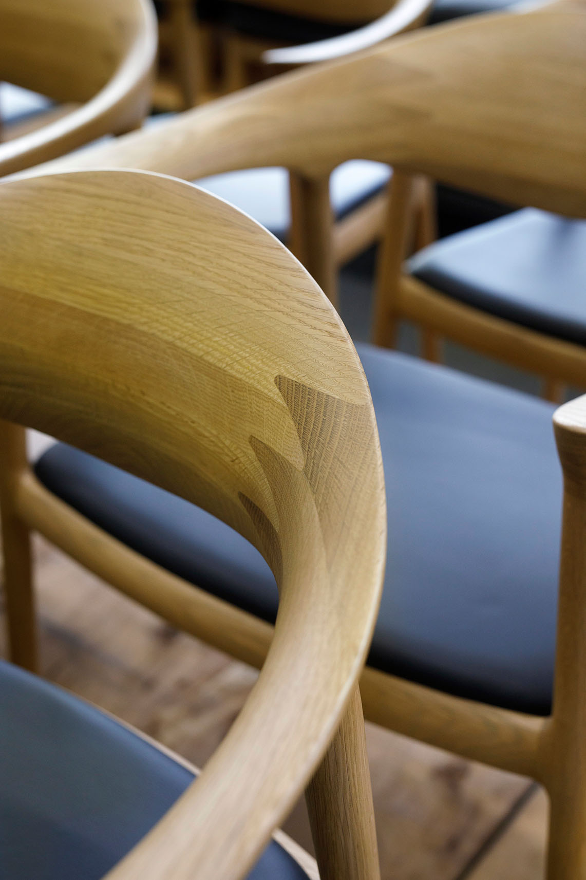 Bridge Arm Chair by Bernstorffsminde Møbelfabrik featuring curved oak frame and upholstered red seat and back.