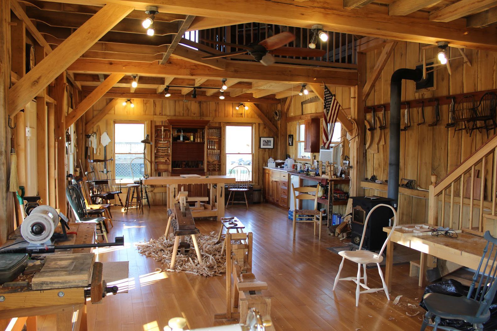 An image of a woodworking workshop for Danish furniture. Warm timber colours and examples of handmade chairs